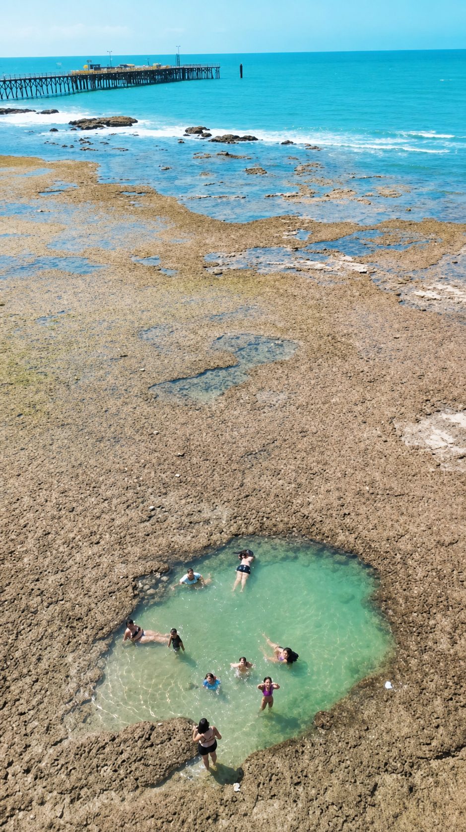 Piscina natural da praia da Pedra Rachada em Paracuru vista de cima, com banhistas dentro